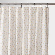 a white shower curtain with gold dots on it