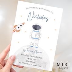 a hand holding up a birthday card with an astronaut on it