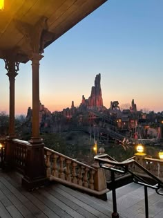 an outdoor patio with lights on the side and a view of a castle in the background