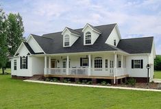 a white house sitting on top of a lush green field