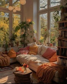 a living room filled with lots of furniture and windows covered in plants on top of them