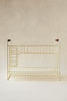 a white wire shelf with two cups on it