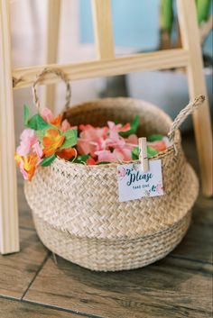 a basket filled with flowers sitting on top of a wooden floor