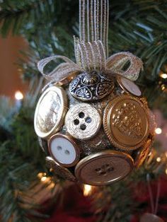 a christmas ornament with buttons on it hanging from a tree in front of some lights