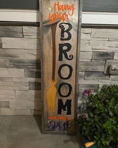 a wooden sign that says broom room on the side of a building next to a potted plant