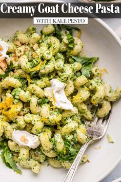 a white bowl filled with pasta covered in pesto and topped with hard boiled eggs