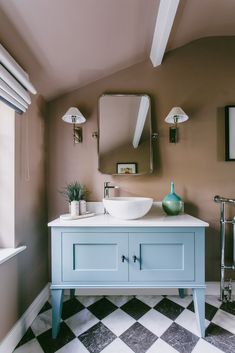 a bathroom with a checkered floor and blue vanity