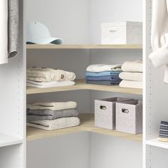 an organized closet with white shelves and folded clothes on the bottom shelf in front of it