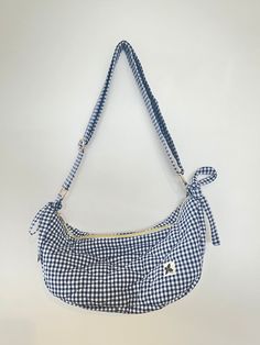 The Daphie Quilted Cross Body bag is the perfect everyday bag with a quirky, handmade vibe! Each bag is unique, with this navy gingham cutie featuring gold hardware, a classic zip, and an internal pocket to store your smaller items! This bag also has removal bows on its straps for that next level cuteness! The bag holds a surprisingly large amount of things, easily holding a 750ml drink bottle, a book, sunnies, keys, a wallet, and more!  This exterior of this Daphie bag was constructed from a re Quilted Cross, Navy Gingham, Drink Bottle, Everyday Bag, Cross Body Bag, Blue Fabric, Body Bag, Cross Body Handbags, Purses And Handbags