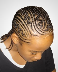 a woman with braids on her hair wearing a black t - shirt and looking down