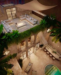 an aerial view of a house with a pool and patio area at night, surrounded by greenery