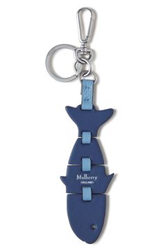 a blue key chain with a shark design on the front and back of it, hanging from a metal hook