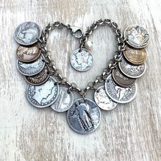 a heart - shaped bracelet with lots of coins attached to it on a wooden surface