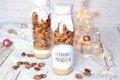 two jars filled with almonds sitting on top of a table next to christmas decorations