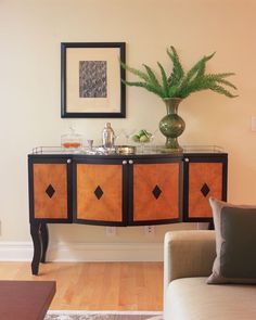 a living room with a couch, table and potted plant on top of it