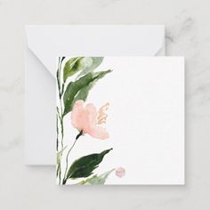 a card with watercolor flowers and leaves on the front, in light pink tones