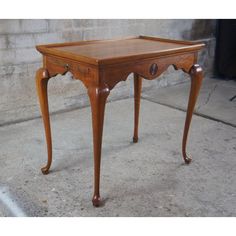 a small wooden table with one drawer on the top