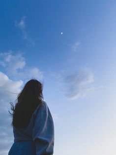 a woman is flying a kite high in the sky