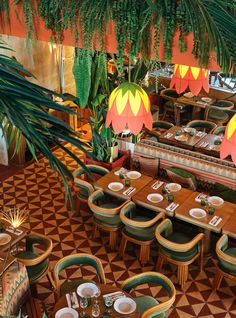 an overhead view of a restaurant with tables and chairs, potted plants, and large chandeliers hanging from the ceiling