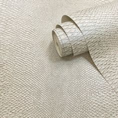 a roll of silver metallic foil on top of a white table cloth with a ribbon