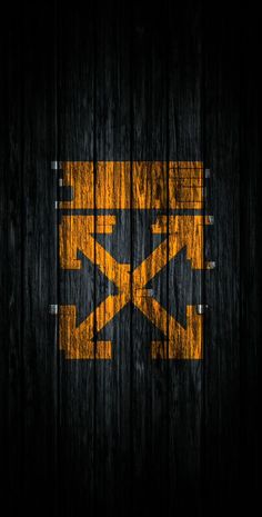 an orange and black wallpaper with the letter k in it's center on a wooden background