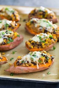 baked sweet potatoes with black beans, corn and cheese on a baking sheet ready to be eaten