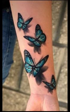 a woman's arm with three blue butterflies on the left side of her wrist