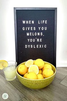 a bowl filled with lemons next to a sign that says when life gives you melons, you're dyslexic