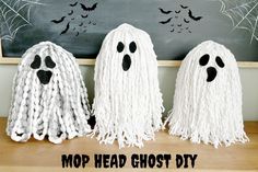 three mop head ghost diy decorations on a table with chalkboard in the background