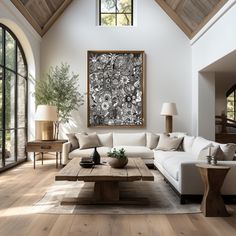 a living room filled with furniture and a large painting hanging on the wall above it