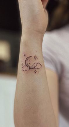 a woman's arm with a small moon and stars tattoo on the left wrist