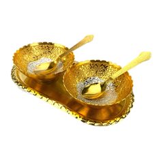 two golden serving dishes with spoons in them