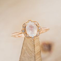 a close up of a diamond ring on a wooden stand