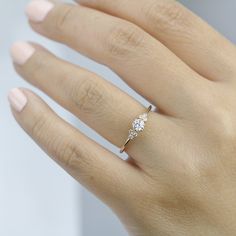 a woman's hand with a diamond ring on it