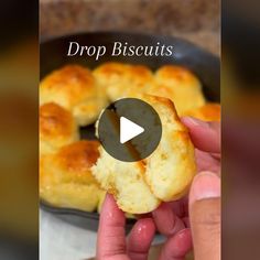 a person holding a piece of bread in their hand with the words drop biscuits on it