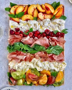 a platter filled with lots of different types of fruits and veggies on top of each other