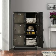 an open metal cabinet with many drawers in the corner and a white table next to it