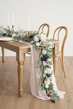 the table is decorated with flowers and greenery for an elegant touch to the dining room