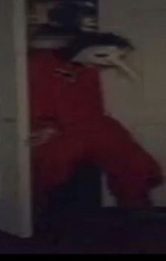 a blurry image of a person in a red suit