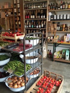 a store filled with lots of different types of vegetables and fruit on display in front of shelves