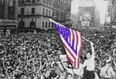 a man holding an american flag in front of a large crowd on a city street