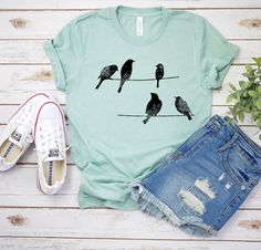 "Birds t-shirt, Birds on a wire, Graphic womens shirt, Graphic birds, Nature shirt, animal, Christmas Gift for family, Brother, Sister Gift Unisex T Shirt is made of super soft lightweight cotton T-shirt is made of Pre-shrunk 100% ultra soft cotton, runs true to size, unisex standard fit shirt » Deep Heather is 52/48 combed and ringspun cotton/polyester, » Sport grey and Black Heather are 90/10 combed and ringspun cotton/polyester » Prism Colors: 99% combed and ring-spun cotton, 1% polyester » l Casual Summer Tops With Bird Print, Casual Bird Print Tops For Summer, Casual Summer T-shirt With Bird Print, Birds On A Wire, Christmas Gift For Family, Single Shirt, Bird Shirt, Birds Nature, Animal Christmas