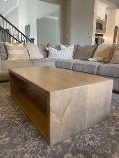 a living room with couches and a coffee table in front of the sofas