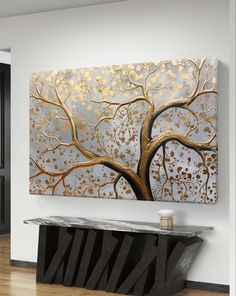 a large painting hanging on the side of a wall next to a black table and chair