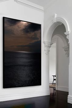 an empty room with a large painting hanging on the wall