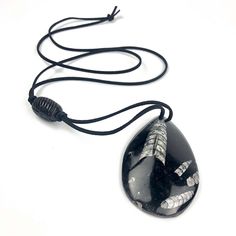 "Simply wonderful x-Large black teardrop cephlapod fossil pendant necklace on black leather with trade bead. The tied closure can be adjusted in length if desired. Necklace Drop Length: 38.5\" Pendant Height: 3.25\" Pendant Width: 2\" Pendant Depth: ~.5\"" Black Pendant Necklace For Everyday Use, Black Adjustable Necklace For Everyday Use, Adjustable Black Necklace For Everyday Use, Black Handmade Teardrop Necklace, Handmade Black Teardrop Necklace, Unique Black Jewelry For Everyday Use, Black Adjustable Teardrop Pendant Necklace, Black Adjustable Artisan Necklace, Southwestern Necklace