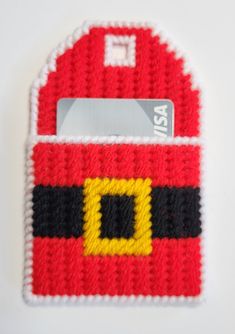 a red and yellow knitted card holder with a credit card slot in the center