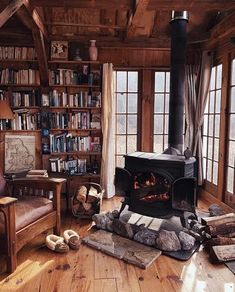 a living room filled with furniture and a fire place in the middle of a wooden floor