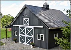 a black and white barn with an american flag on the roof