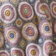 a crocheted blanket with multicolored circles on it